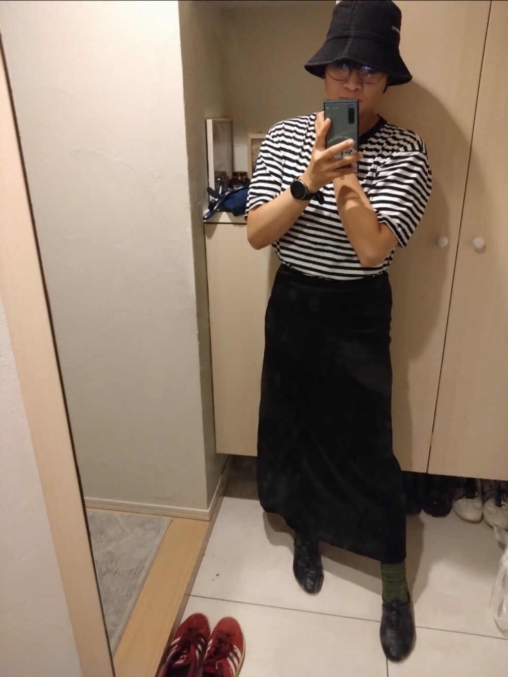 ブラック系のスカートを着用したレディースの秋コーディネートの2枚目の写真