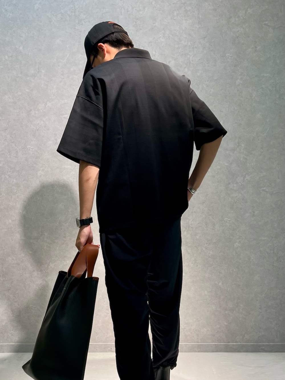 ブラック系のポロシャツ、ブラック系のその他パンツ、ブラック系のブーツを着用したメンズの夏コーディネートの3枚目の写真