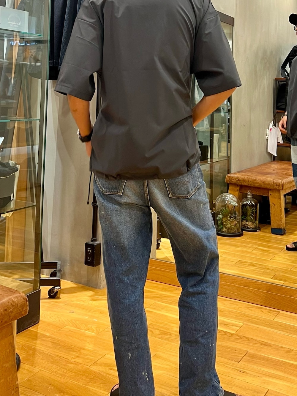 グレー系のTシャツ/カットソー、ブルー系のデニムパンツ、ブラック系のキャップを着用したメンズの夏コーディネートの3枚目の写真