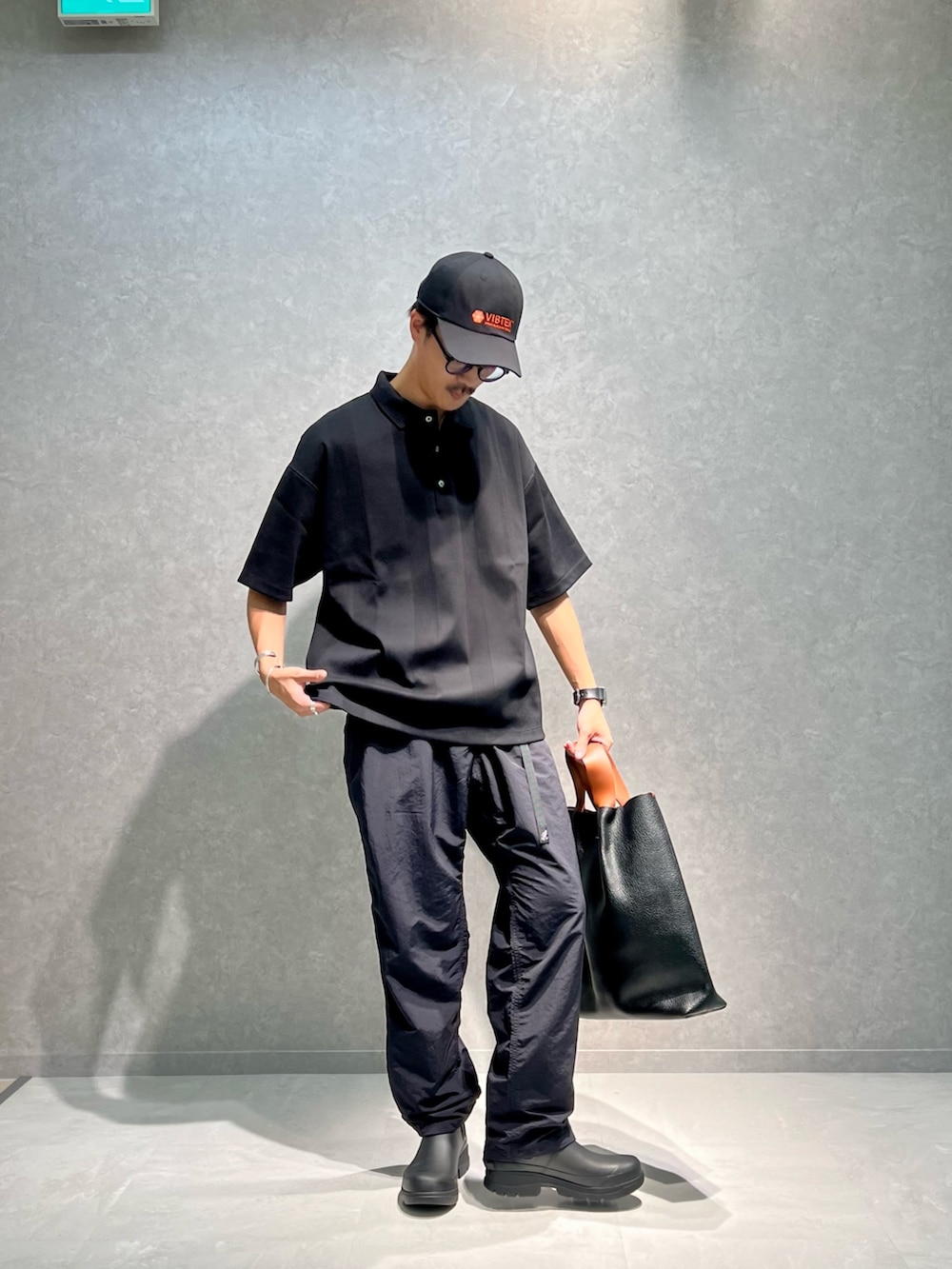 ブラック系のポロシャツ、ブラック系のその他パンツ、ブラック系のブーツを着用したメンズの夏コーディネートの2枚目の写真