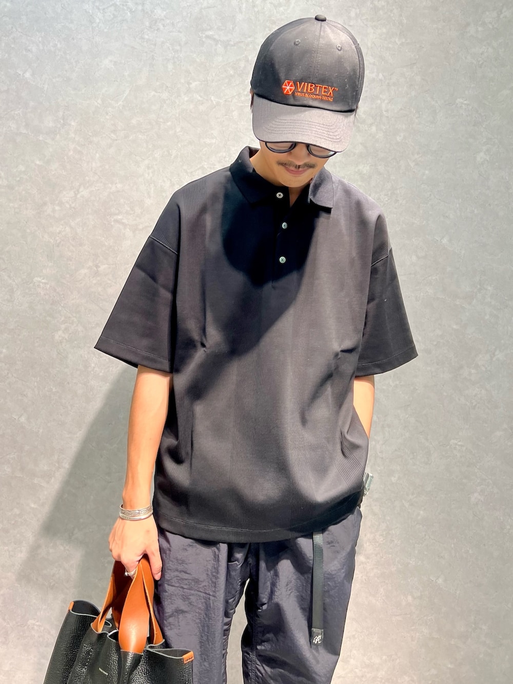 ブラック系のポロシャツ、ブラック系のその他パンツ、ブラック系のブーツを着用したメンズの夏コーディネートの4枚目の写真