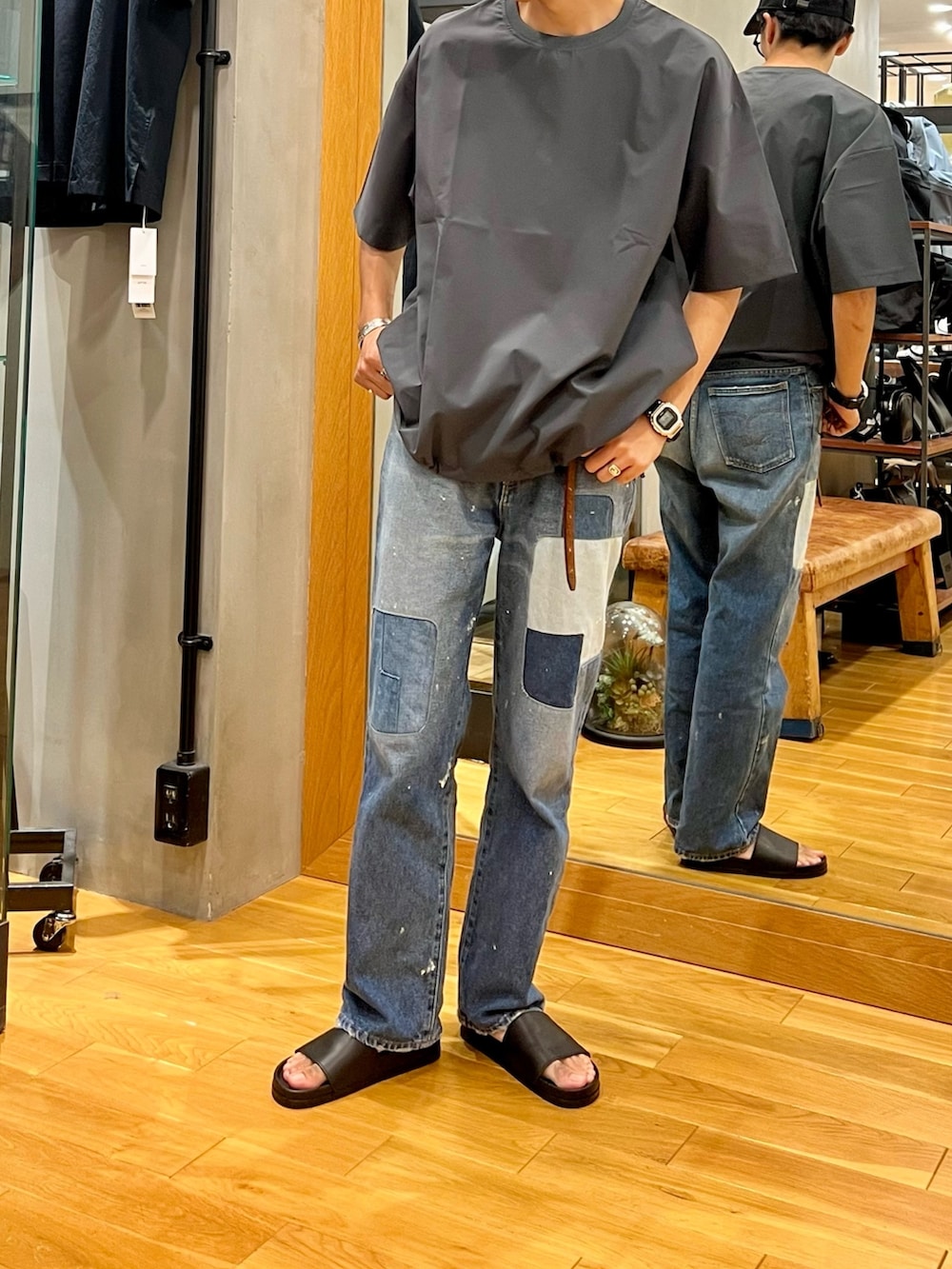 グレー系のTシャツ/カットソー、ブルー系のデニムパンツ、ブラック系のキャップを着用したメンズの夏コーディネートの2枚目の写真