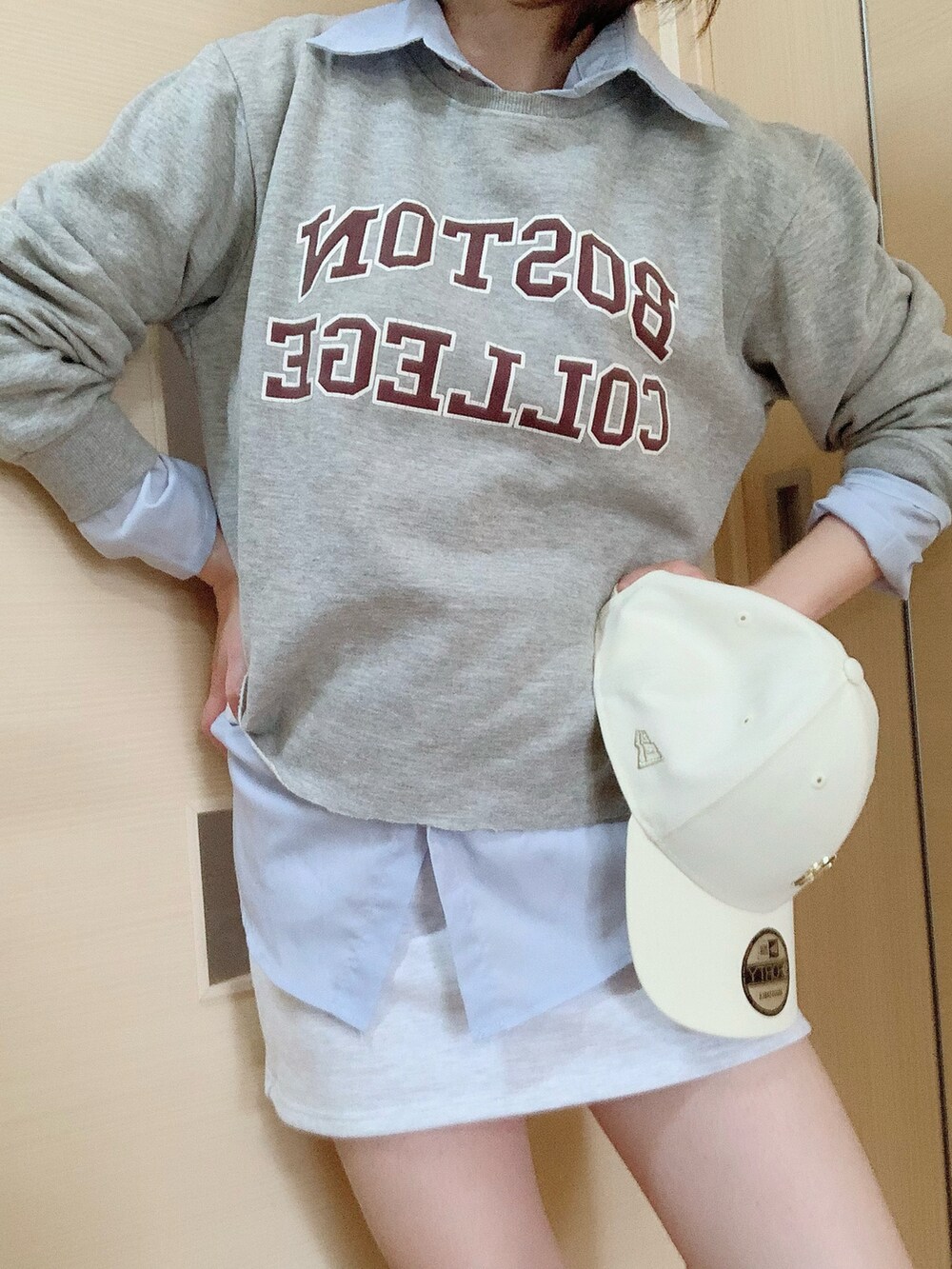 グレー系のトップス、ホワイト系のキャップを着用したレディースの秋コーディネートの2枚目の写真