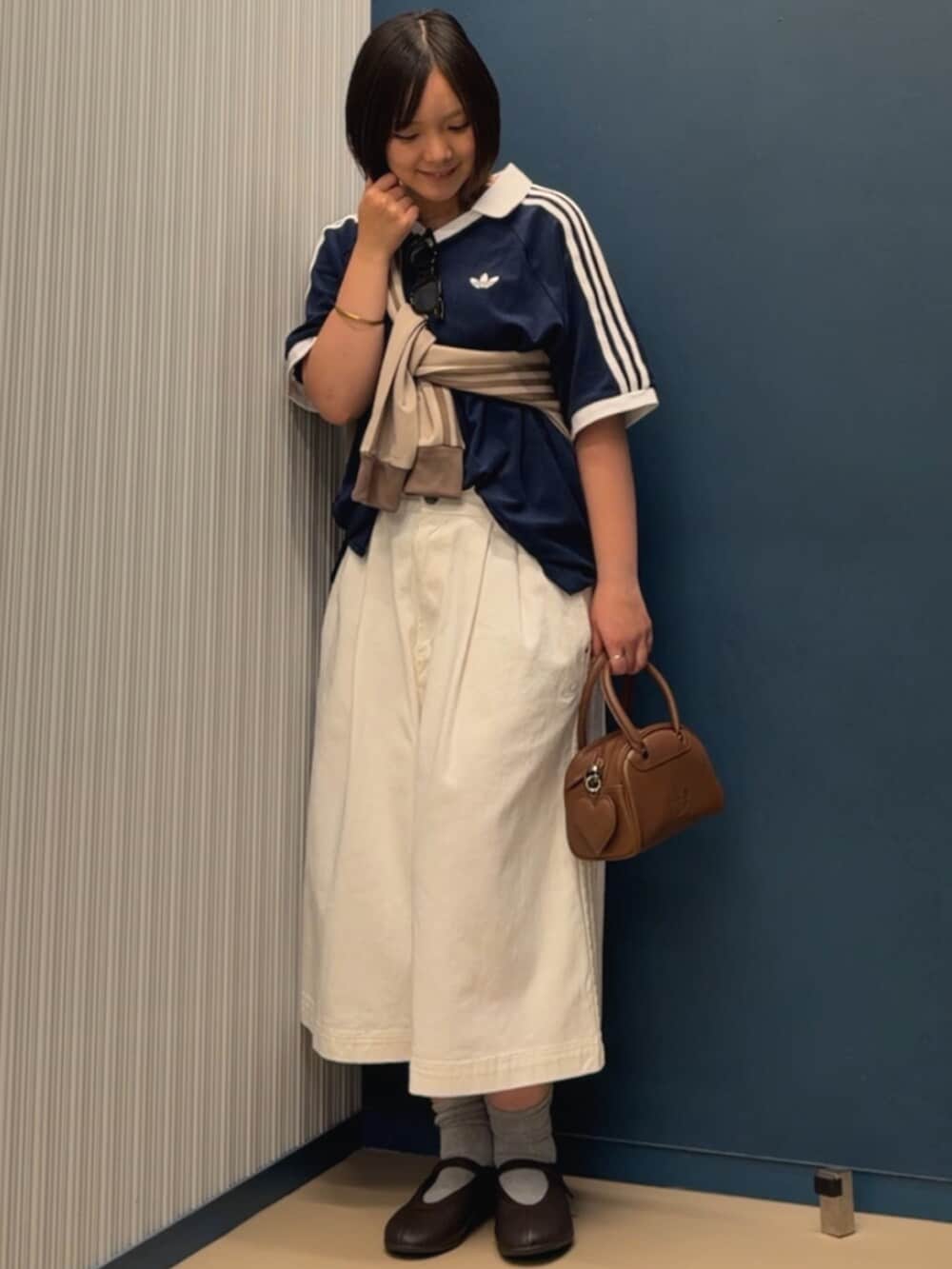 ブルー系のトップス、ブラウン系のバレエシューズ、ベージュ系のジャージを着用したレディースの夏コーディネートの2枚目の写真