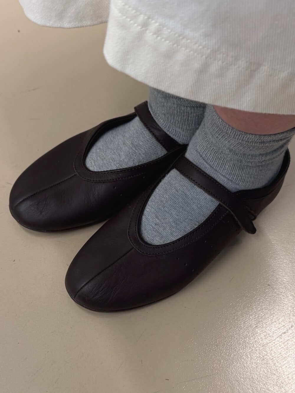 ブルー系のトップス、ブラウン系のバレエシューズ、ベージュ系のジャージを着用したレディースの夏コーディネートの6枚目の写真