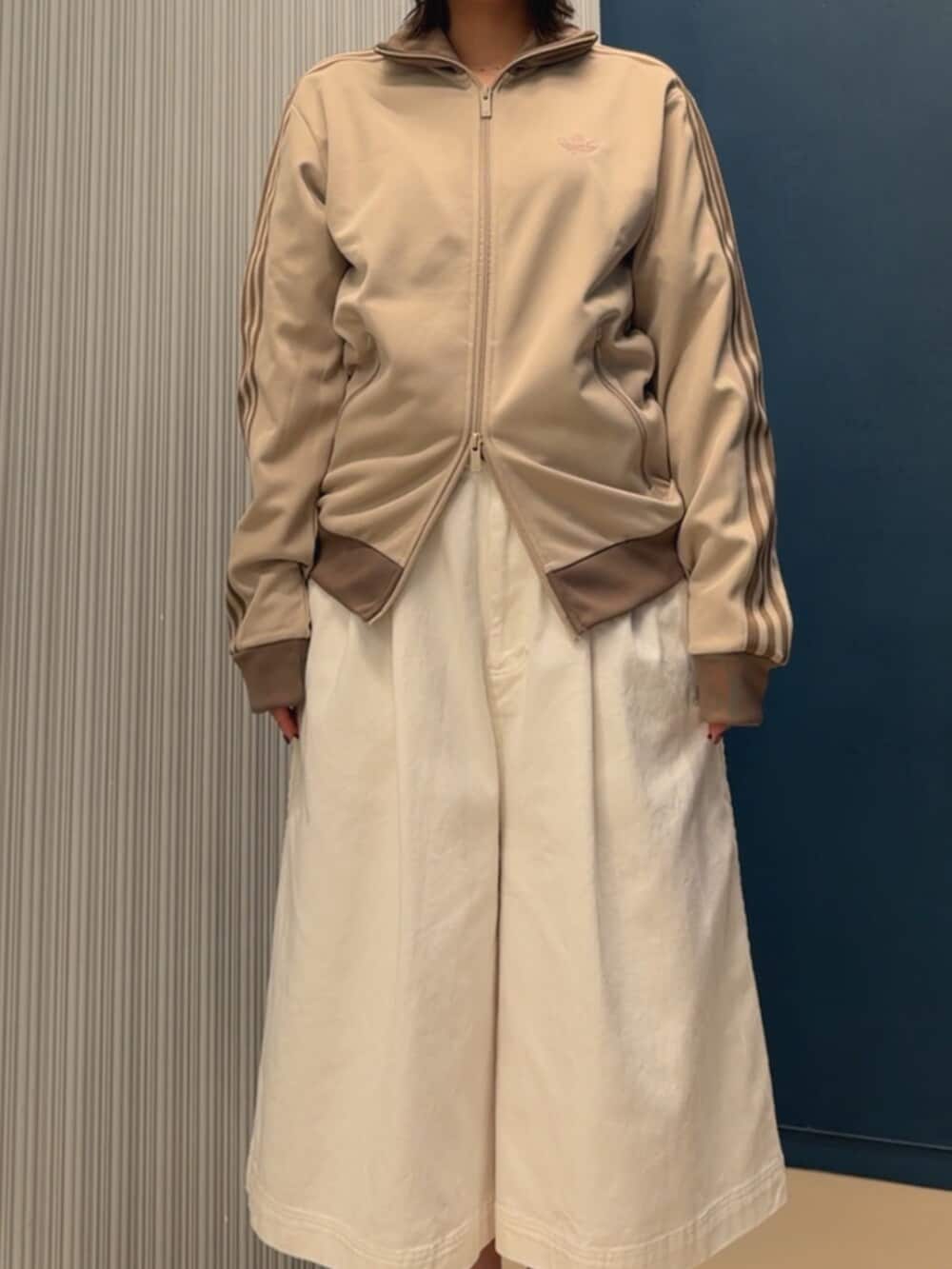 ブルー系のトップス、ブラウン系のバレエシューズ、ベージュ系のジャージを着用したレディースの夏コーディネートの3枚目の写真