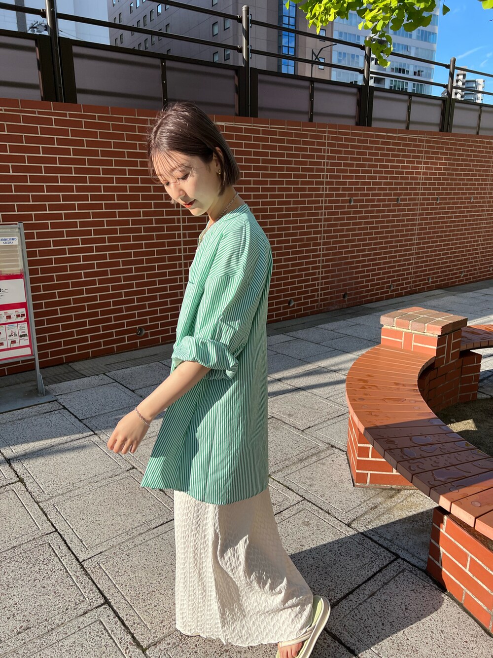 グリーン系のシャツ/ブラウス、ホワイト系のワンピース、イエロー系のネックレスを着用したレディースの春コーディネートの2枚目の写真