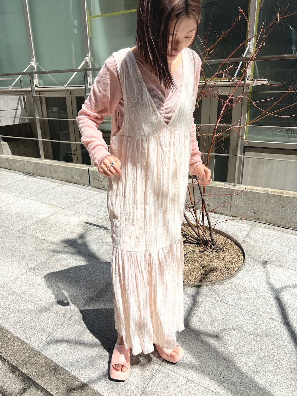 ピンク系のTシャツ/カットソー、ホワイト系のワンピース、ピンク系のサンダルを着用したレディースの春コーディネートの2枚目の写真