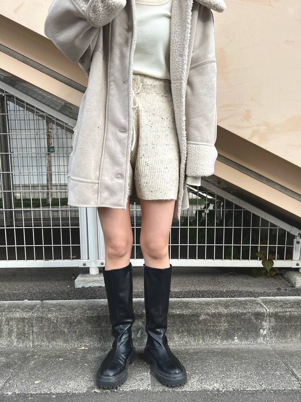 ホワイト系のムートンコート、ホワイト系のTシャツ/カットソー、ホワイト系のその他パンツを着用したレディースの冬コーディネートの4枚目の写真