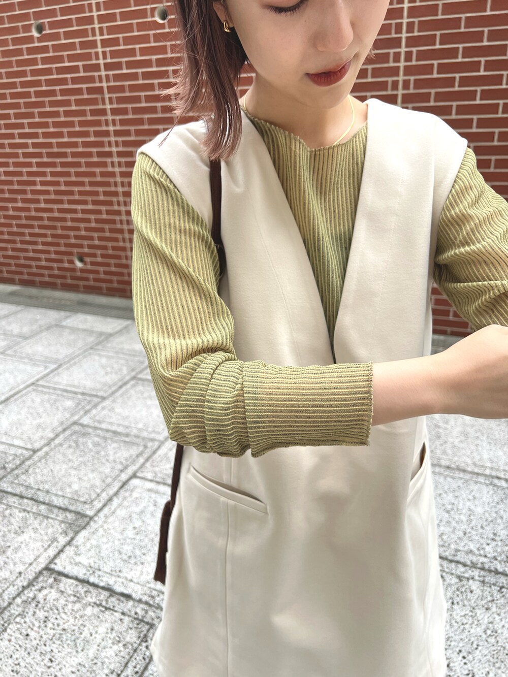 ホワイト系のベスト、グリーン系のTシャツ/カットソー、ブラック系のその他パンツを着用したレディースの秋コーディネートの5枚目の写真