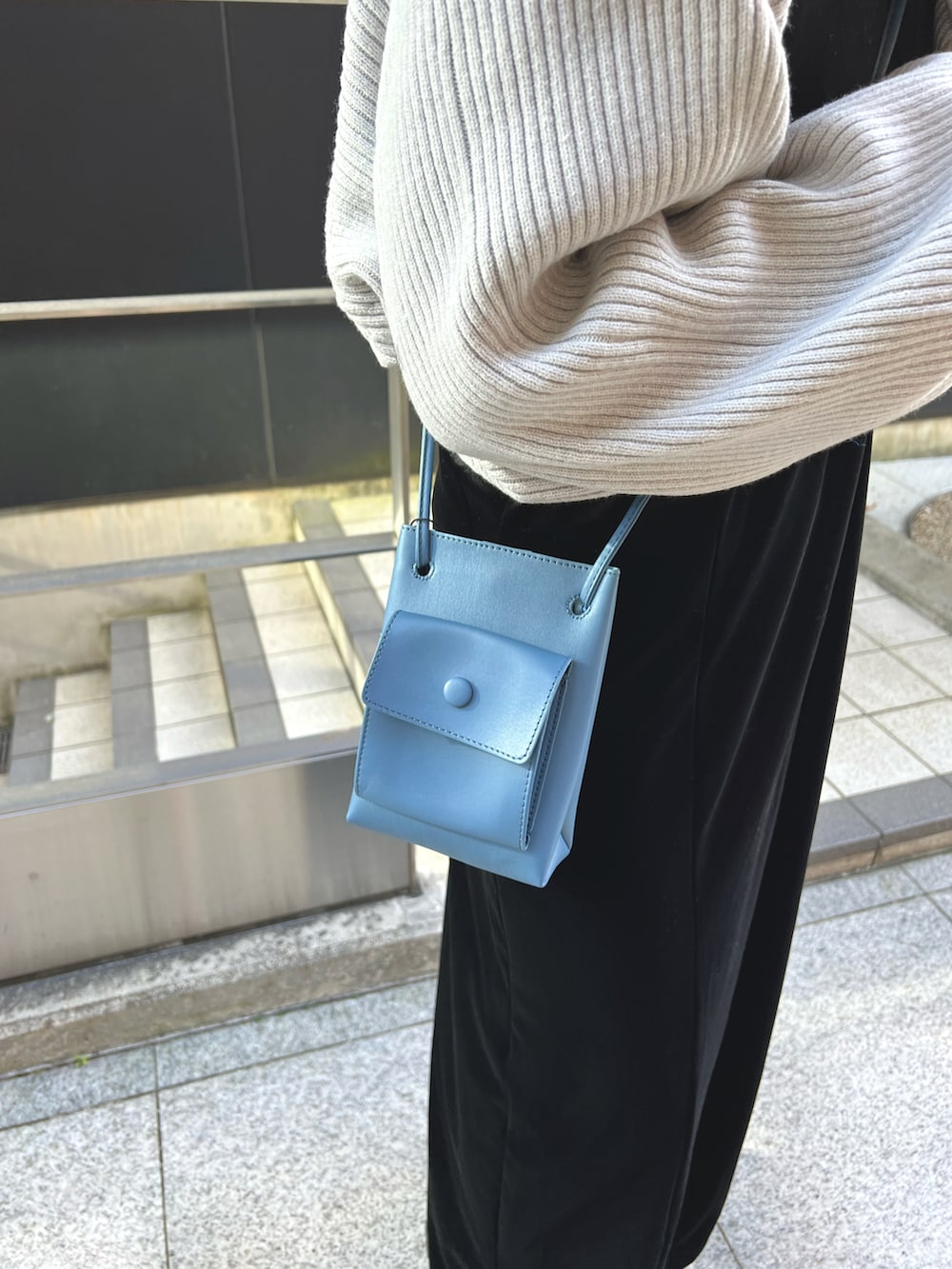 グレー系のカーディガン/ボレロ、ブラック系のワンピース、ブルー系のショルダーバッグを着用したレディースの秋コーディネートの5枚目の写真