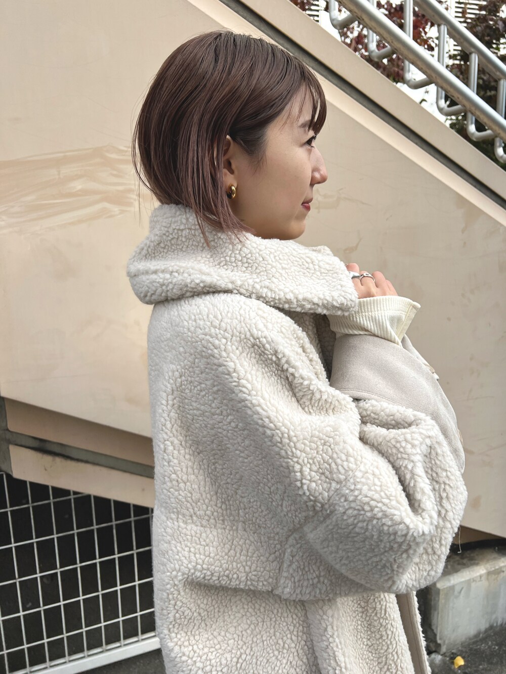 ホワイト系のムートンコート、ホワイト系のTシャツ/カットソー、ホワイト系のその他パンツを着用したレディースの冬コーディネートの2枚目の写真