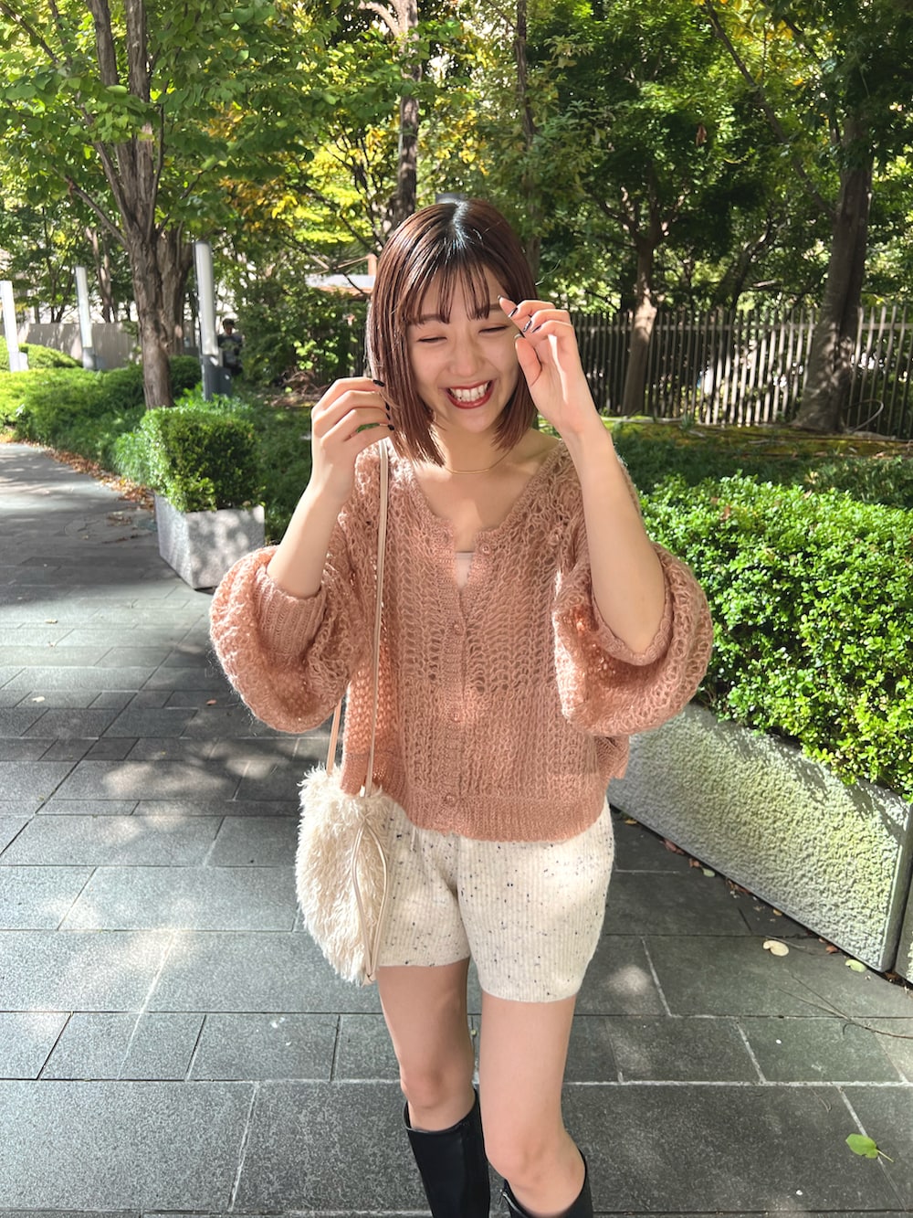 ピンク系のカーディガン/ボレロ、ホワイト系のその他パンツ、ホワイト系のショルダーバッグを着用したレディースの秋コーディネートの2枚目の写真