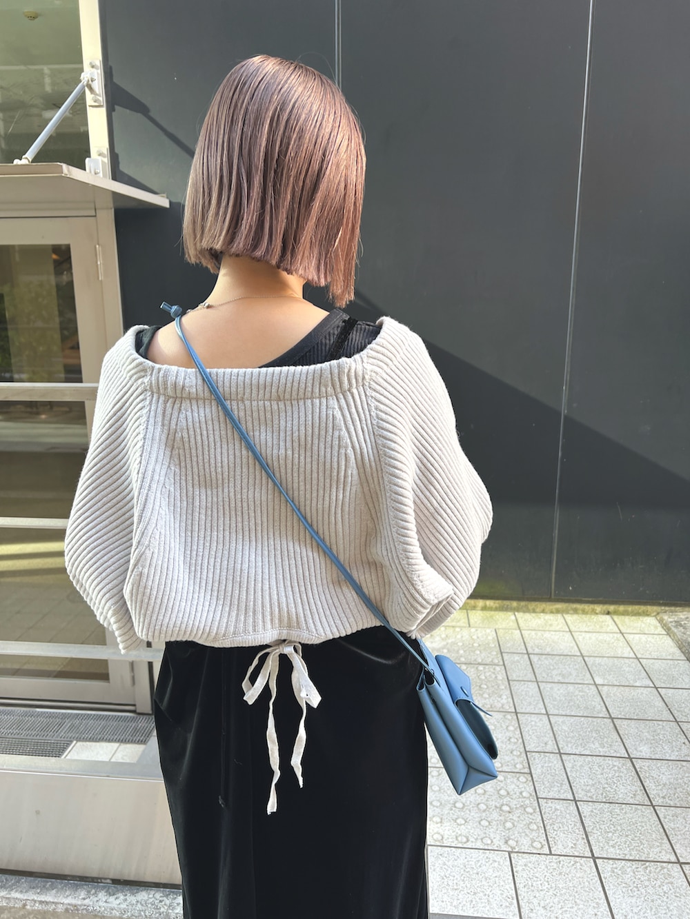 グレー系のカーディガン/ボレロ、ブラック系のワンピース、ブルー系のショルダーバッグを着用したレディースの秋コーディネートの4枚目の写真