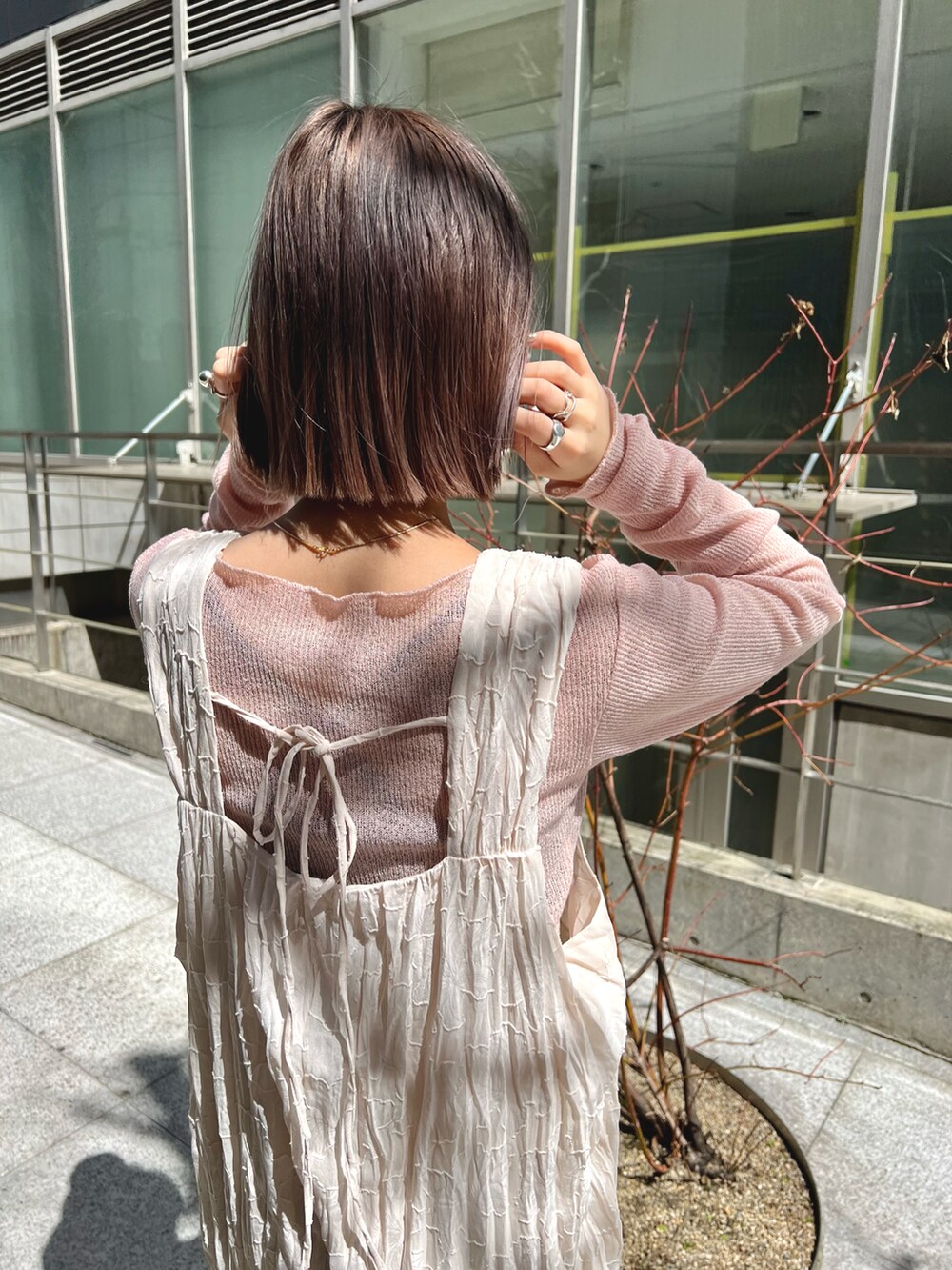 ピンク系のTシャツ/カットソー、ホワイト系のワンピース、ピンク系のサンダルを着用したレディースの春コーディネートの3枚目の写真