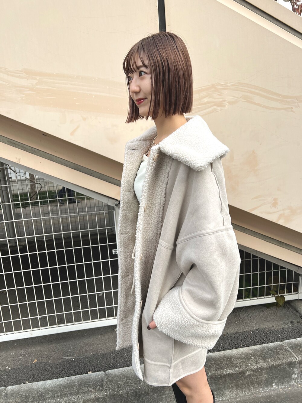 ホワイト系のムートンコート、ホワイト系のTシャツ/カットソー、ホワイト系のその他パンツを着用したレディースの冬コーディネートの5枚目の写真