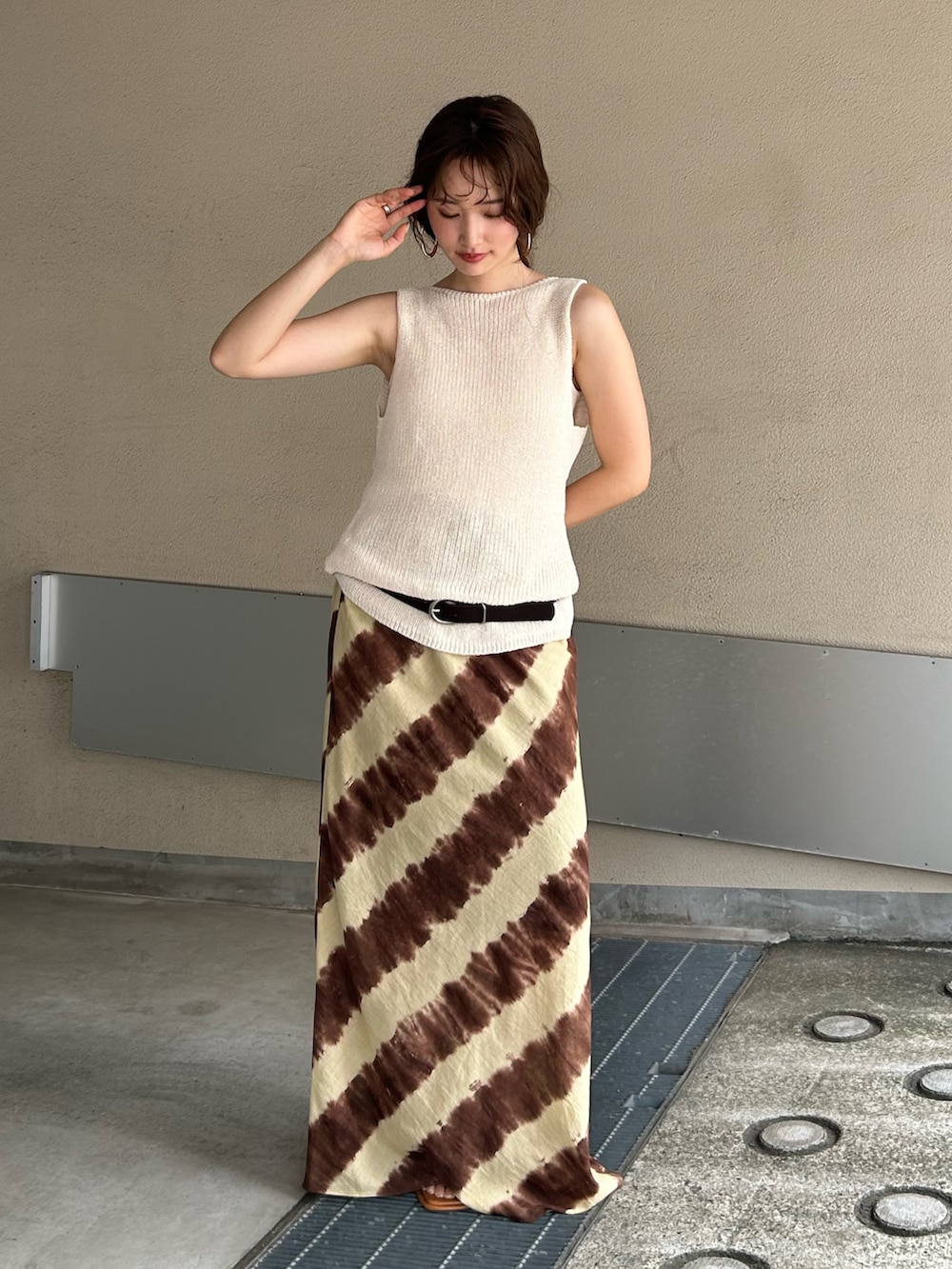 ホワイト系のニット/セーター、ブラウン系のスカート、その他のサンダルを着用したレディースの夏コーディネートの2枚目の写真