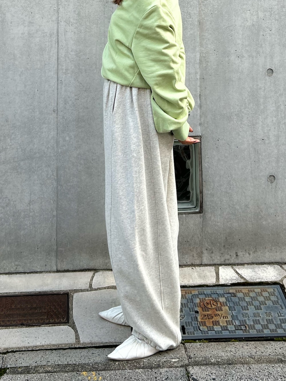 ホワイト系のパンプス、ホワイト系のスウェットパンツ、グリーン系のTシャツ/カットソーを着用したレディースの冬コーディネートの5枚目の写真