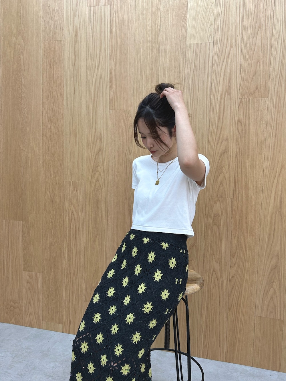 グレー系のスカート、ホワイト系のTシャツ/カットソー、シルバー系のサンダルを着用したレディースの春コーディネートの5枚目の写真