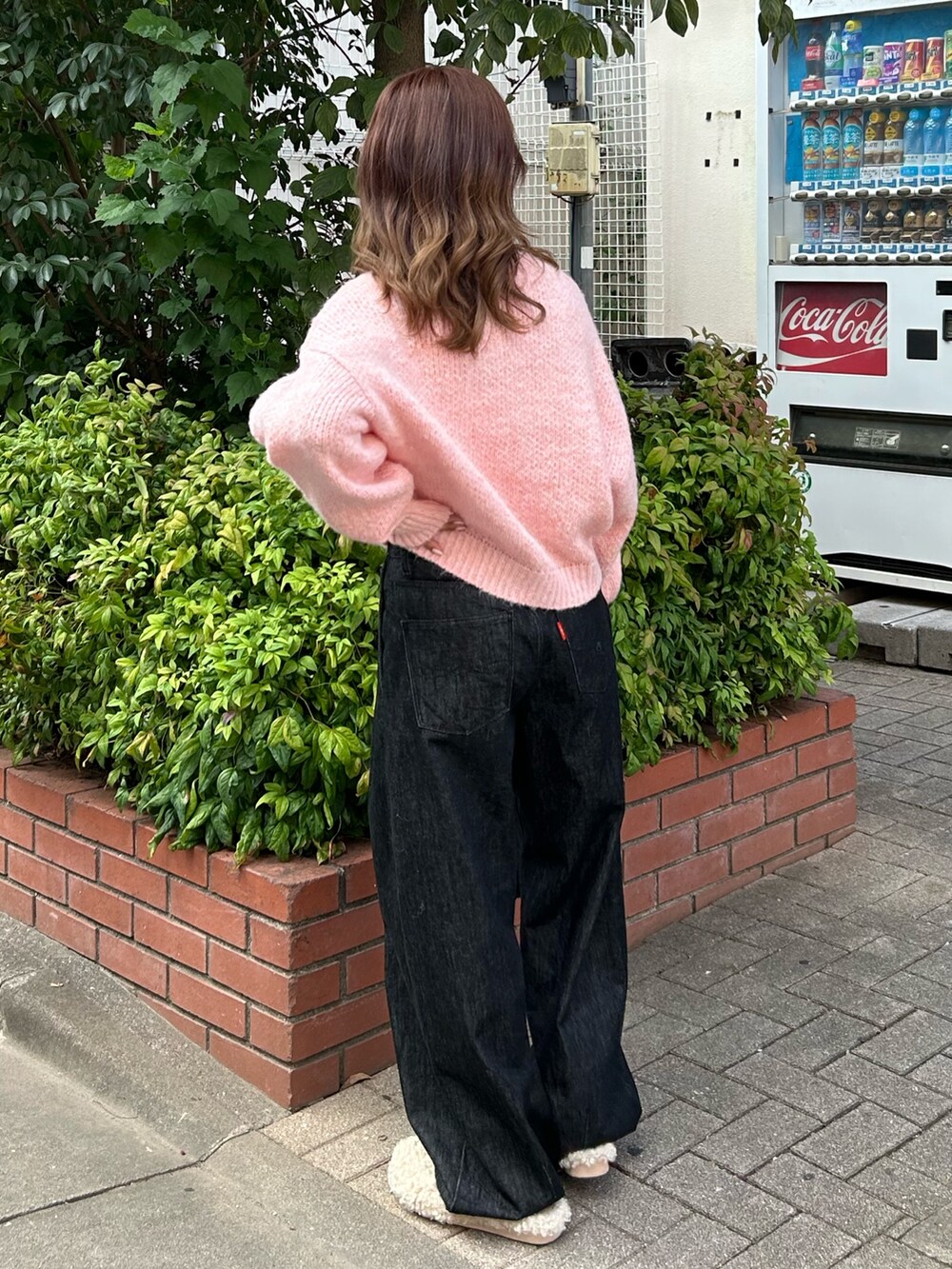 ピンク系のニット/セーター、ブラック系のデニムパンツ、ブラック系のショルダーバッグを着用したレディースの秋コーディネートの4枚目の写真