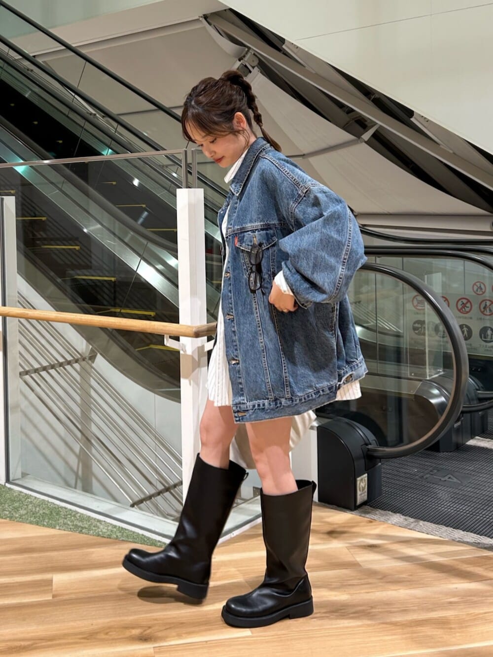 ブルー系のデニムジャケット、ホワイト系のシャツ/ブラウス、ブラック系のブーツを着用したレディースの冬コーディネートの4枚目の写真