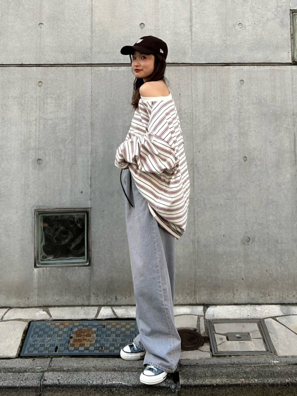 ブルー系のスニーカー、ブルー系のデニムパンツ、ブラック系のベルトを着用したレディースの冬コーディネートの2枚目の写真