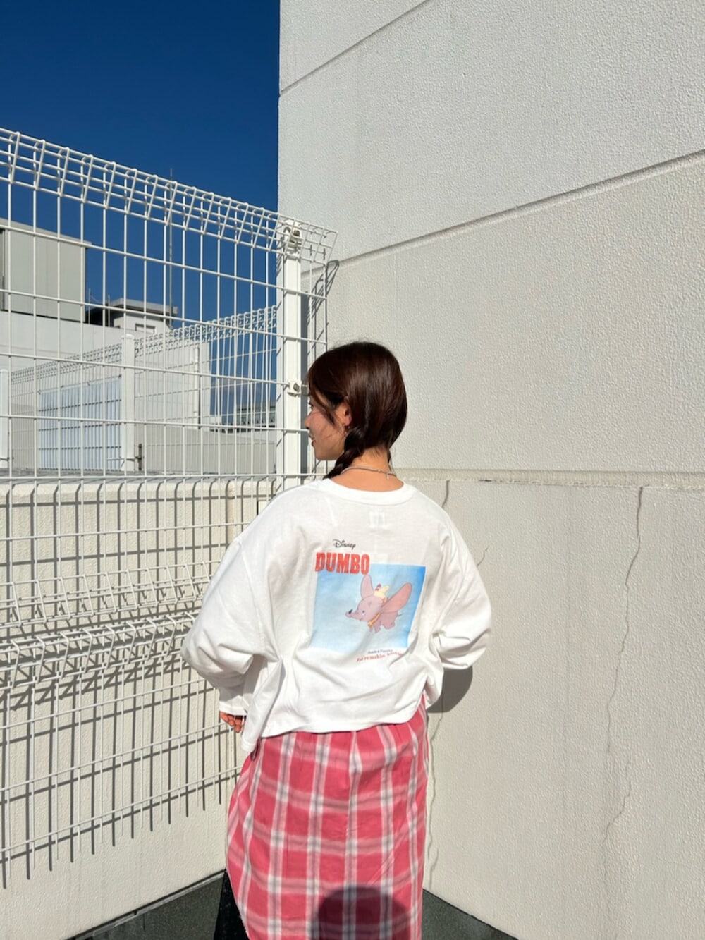 ホワイト系のTシャツ/カットソー、レッド系のシャツ/ブラウス、ブラック系のスカートを着用したレディースの冬コーディネートの6枚目の写真