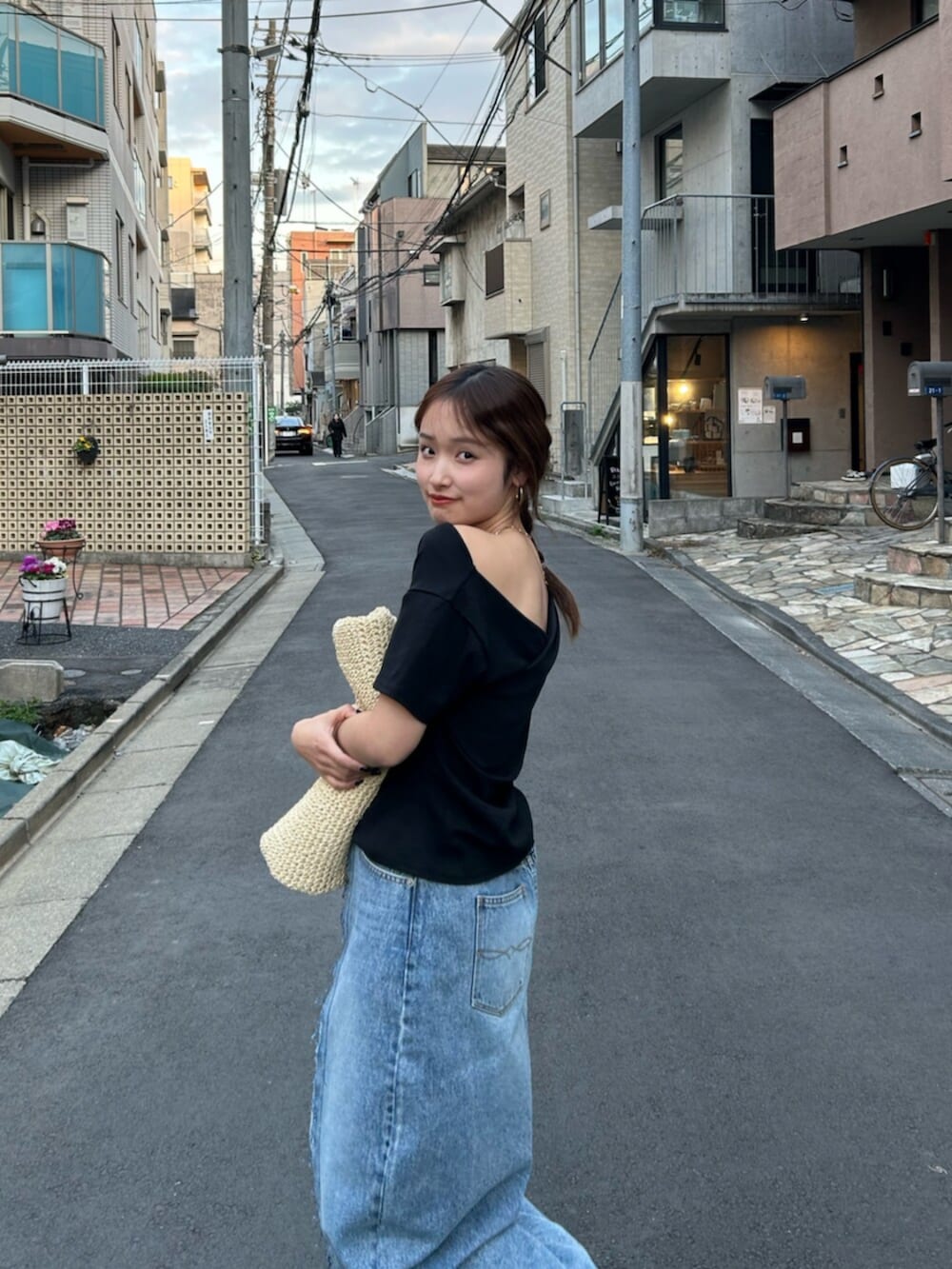 ブルー系のスカート、ベージュ系のハンドバッグ、ベージュ系のブーツを着用したレディースの冬コーディネートの6枚目の写真