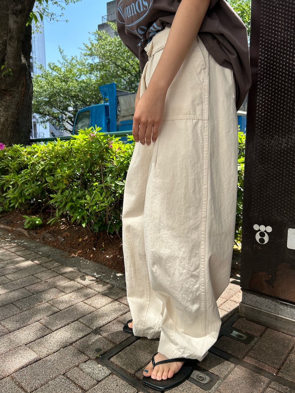 ブラウン系のTシャツ/カットソー、ブラック系のサンダル、ホワイト系のその他パンツを着用したレディースの春コーディネートの5枚目の写真