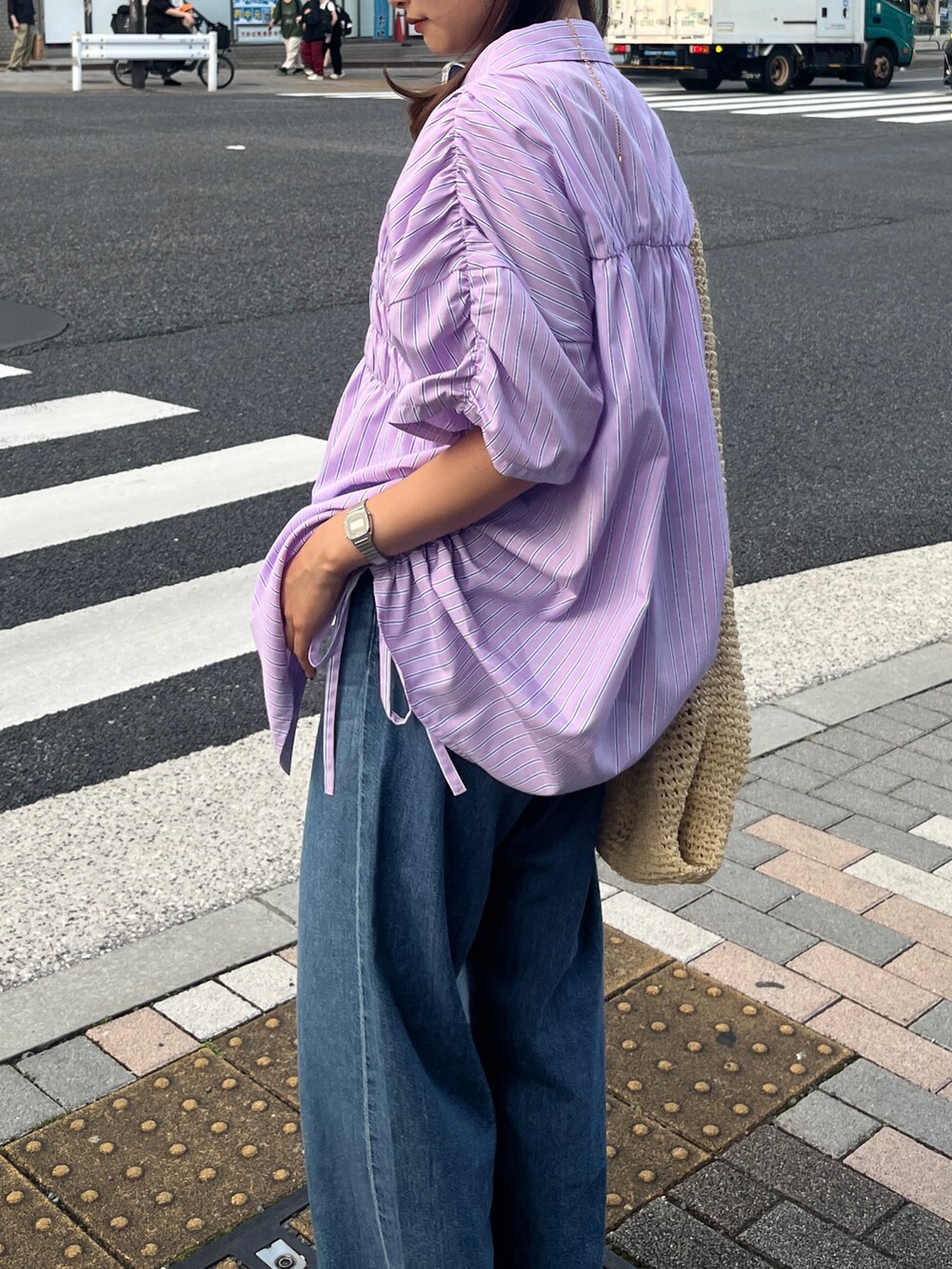 ブルー系のデニムパンツ、ブラック系のサンダル、パープル系のシャツ/ブラウスを着用したレディースの夏コーディネートの6枚目の写真