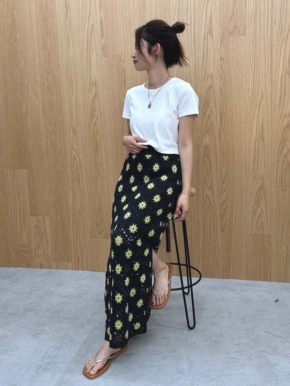 グレー系のスカート、ホワイト系のTシャツ/カットソー、シルバー系のサンダルを着用したレディースの春コーディネートの7枚目の写真