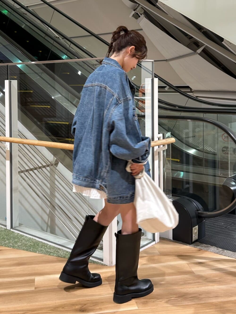 ブルー系のデニムジャケット、ホワイト系のシャツ/ブラウス、ブラック系のブーツを着用したレディースの冬コーディネートの6枚目の写真