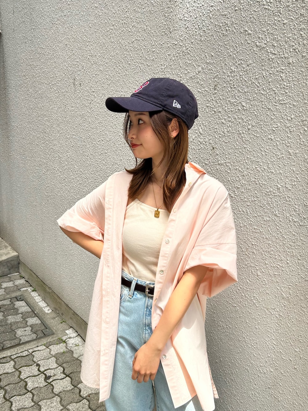 ブルー系のデニムパンツ、ピンク系のシャツ/ブラウス、ホワイト系のキャミソールを着用したレディースの春コーディネートの6枚目の写真