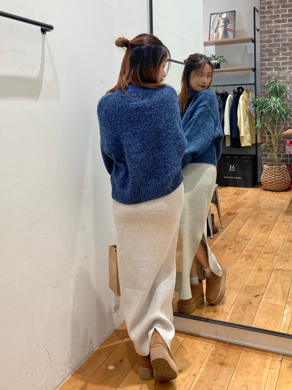 グレー系のスカート、ブルー系のTシャツ/カットソー、ブルー系のニット/セーターを着用したレディースの冬コーディネートの3枚目の写真