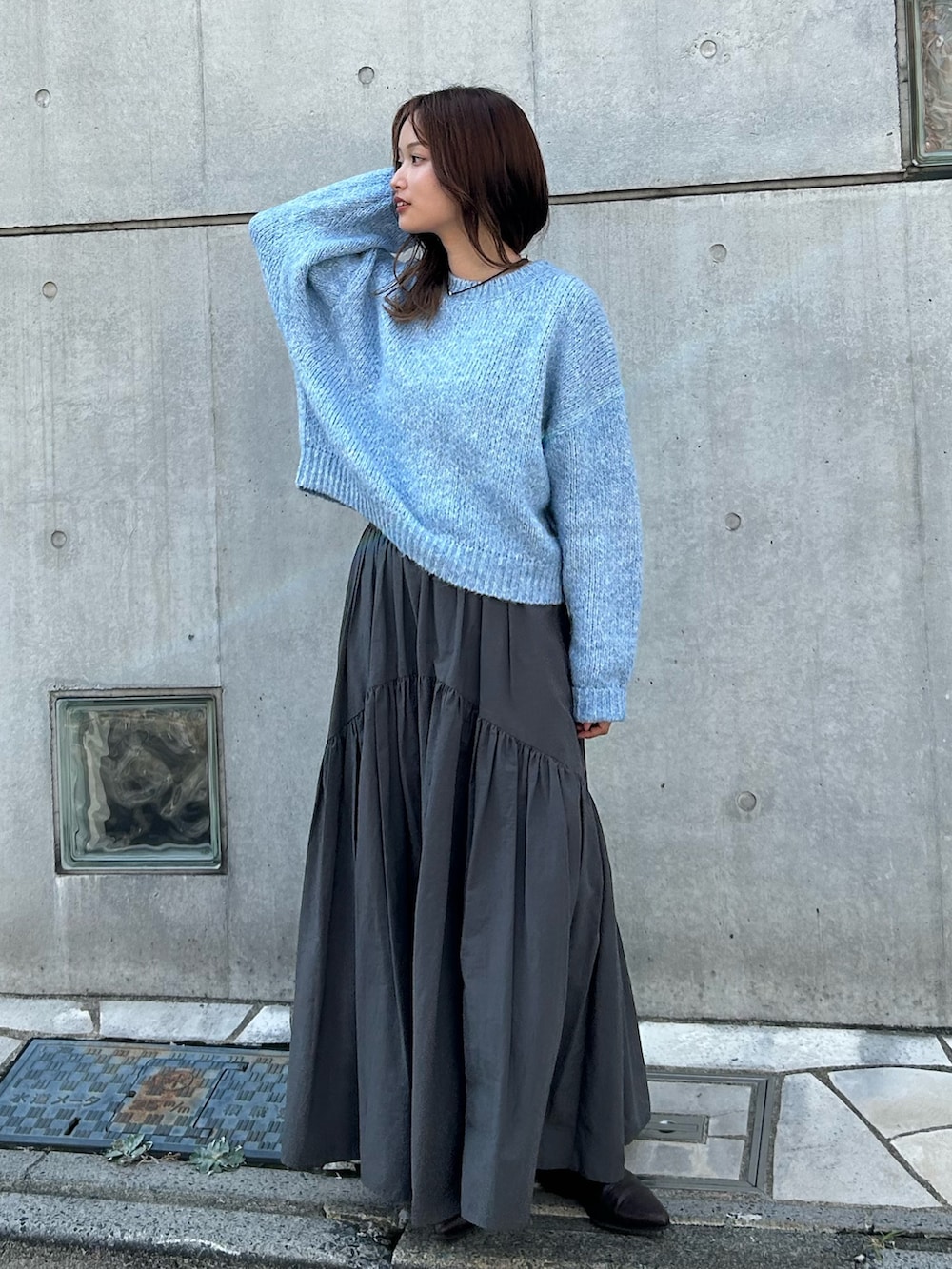 グレー系のスカート、ブラック系のネックレスを着用したレディースの秋コーディネートの2枚目の写真