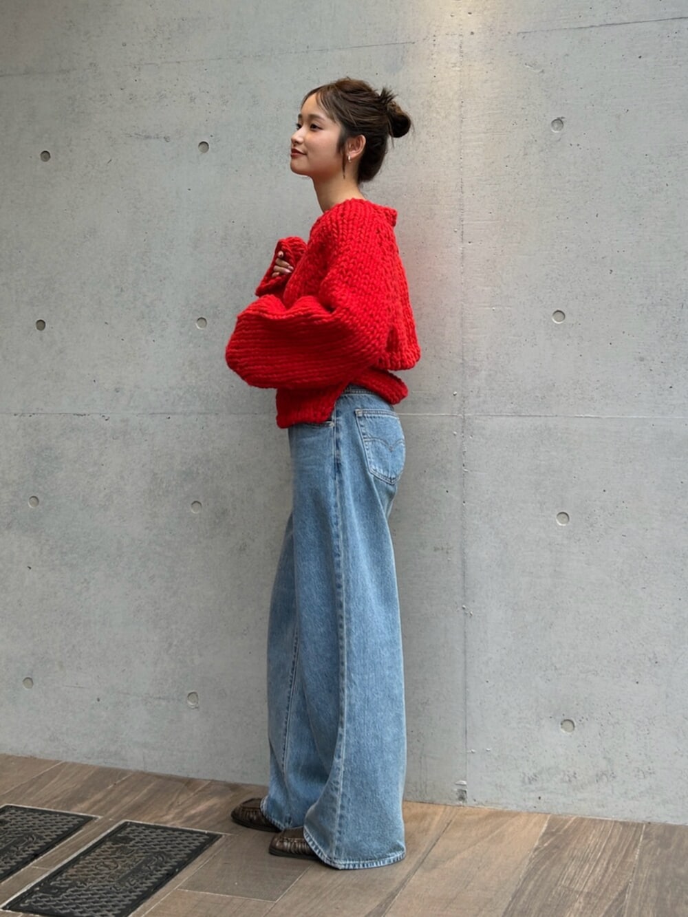 ブルー系のデニムパンツ、レッド系のニット/セーターを着用したレディースの秋コーディネートの3枚目の写真
