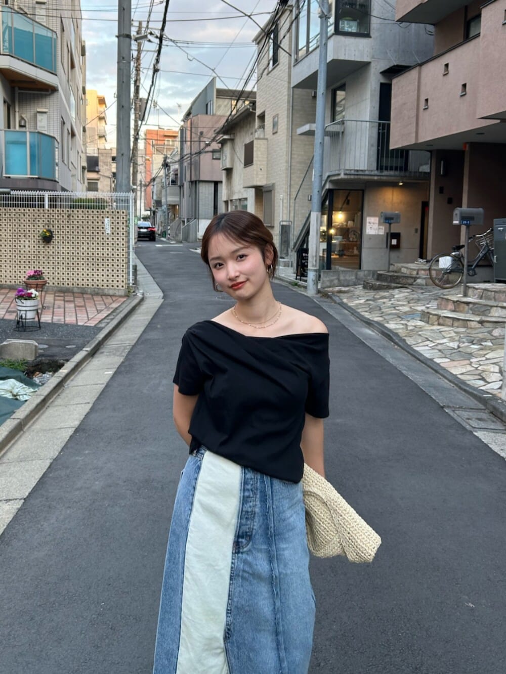 ブルー系のスカート、ベージュ系のハンドバッグ、ベージュ系のブーツを着用したレディースの冬コーディネートの5枚目の写真