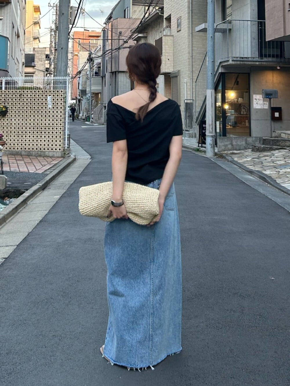 ブルー系のスカート、ベージュ系のハンドバッグ、ベージュ系のブーツを着用したレディースの冬コーディネートの4枚目の写真