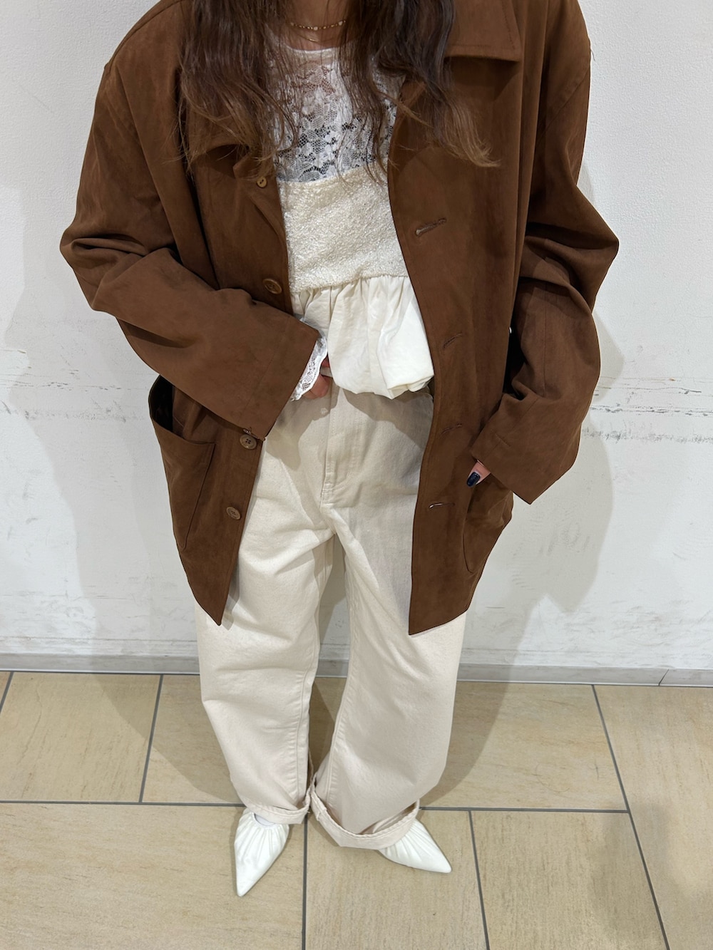 ブラウン系のテーラードジャケット、ホワイト系のパンプス、ホワイト系のデニムパンツを着用したレディースの冬コーディネートの5枚目の写真