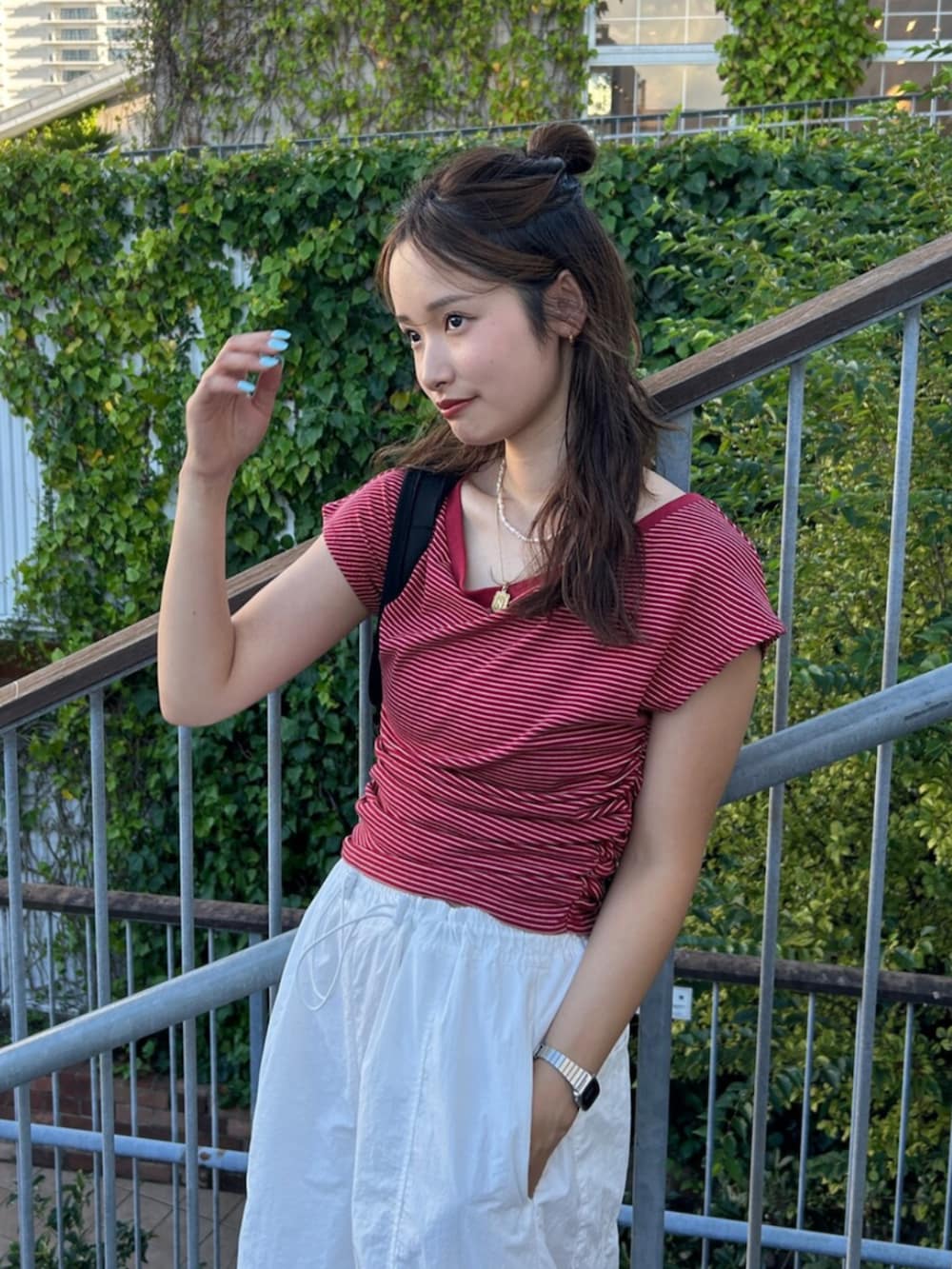 ブラック系のバックパック/リュック、ホワイト系のその他パンツ、レッド系のTシャツ/カットソーを着用したレディースの夏コーディネートの5枚目の写真