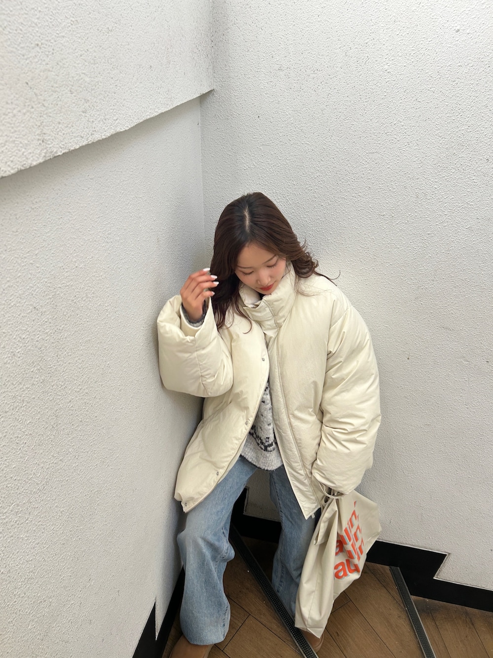 グレー系のニット/セーター、ブルー系のデニムパンツ、レッド系のニット/セーターを着用したレディースの冬コーディネートの6枚目の写真