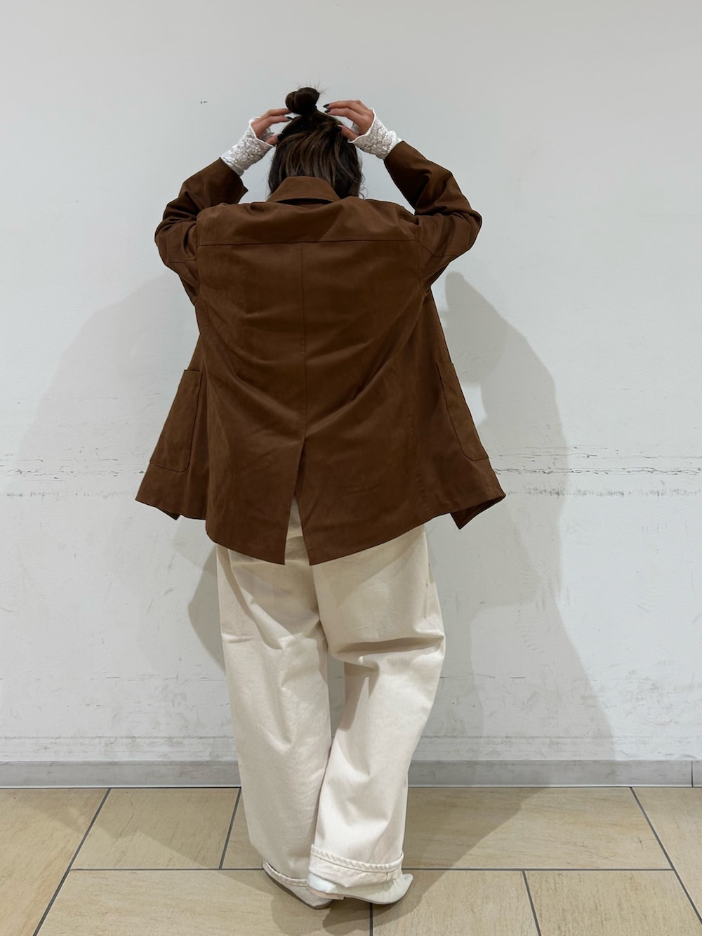 ブラウン系のテーラードジャケット、ホワイト系のパンプス、ホワイト系のデニムパンツを着用したレディースの冬コーディネートの4枚目の写真