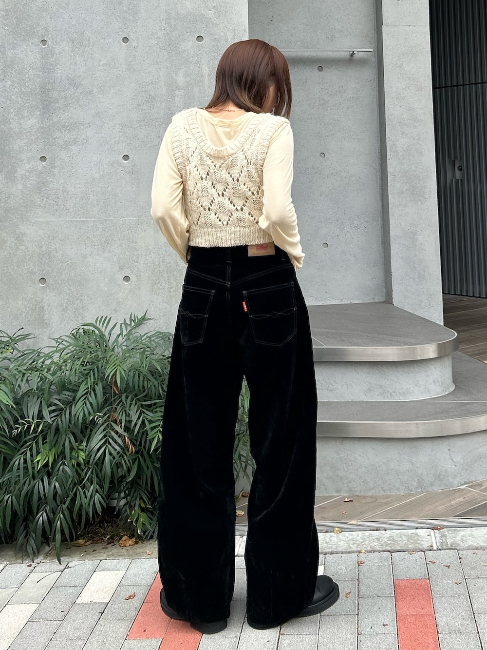 イエロー系のTシャツ/カットソー、ホワイト系のワンピース、ブラック系のデニムパンツを着用したレディースの秋コーディネートの4枚目の写真