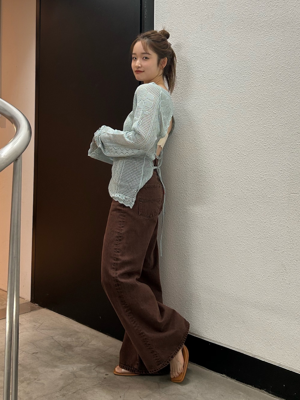 ブラウン系のデニムパンツ、ブルー系のニット/セーターを着用したレディースの春コーディネートの4枚目の写真