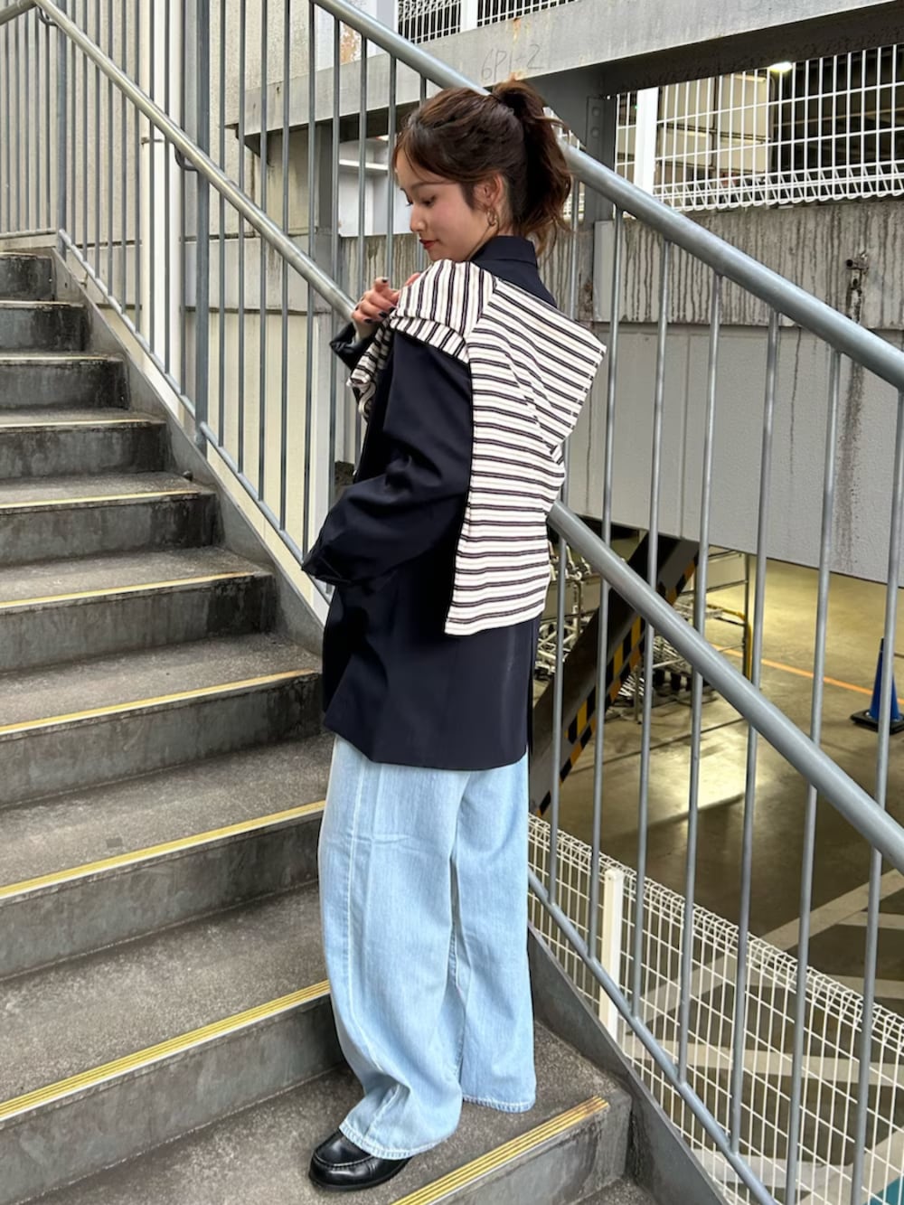 イエロー系のニット/セーター、ブルー系のテーラードジャケット、ブルー系のデニムパンツを着用したレディースの冬コーディネートの2枚目の写真