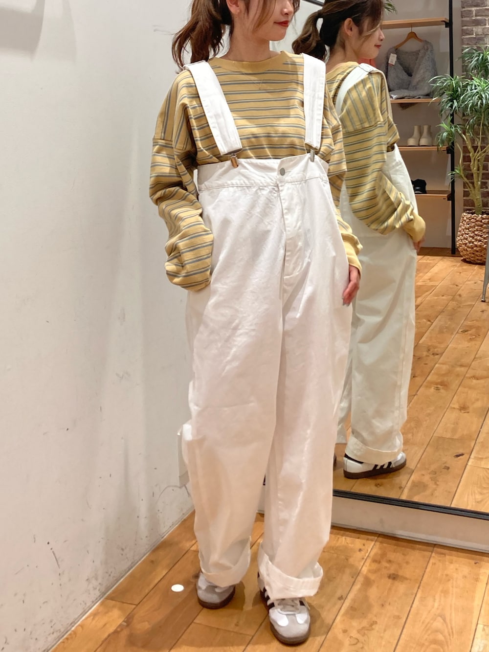 イエロー系のTシャツ/カットソー、ホワイト系のつなぎ/オールインワンを着用したレディースの冬コーディネートの2枚目の写真