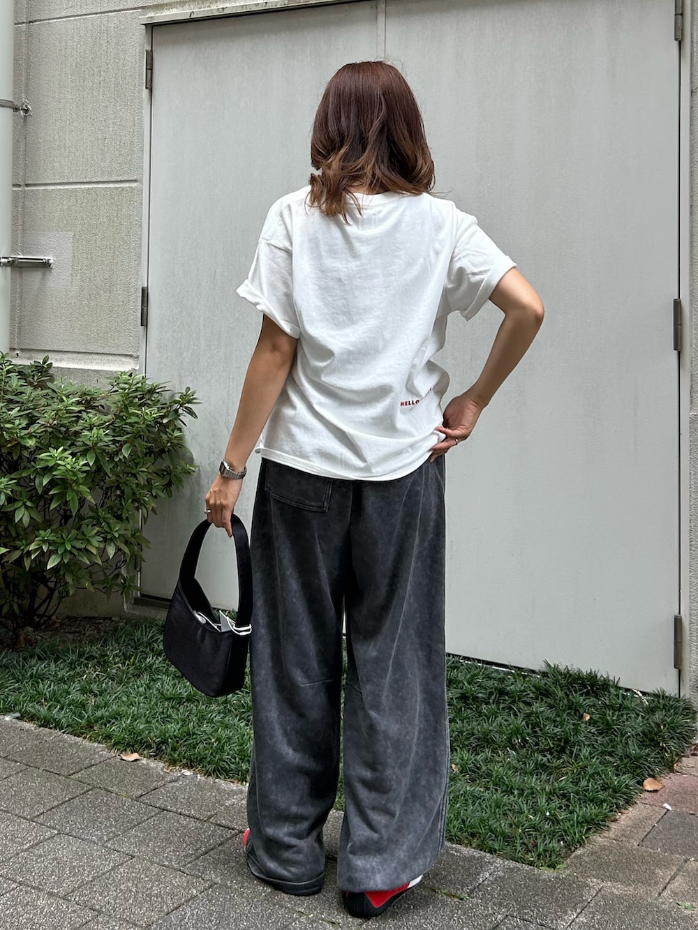 グレー系のスウェットパンツ、ブラック系のハンドバッグ、ホワイト系のTシャツ/カットソーを着用したレディースの夏コーディネートの4枚目の写真