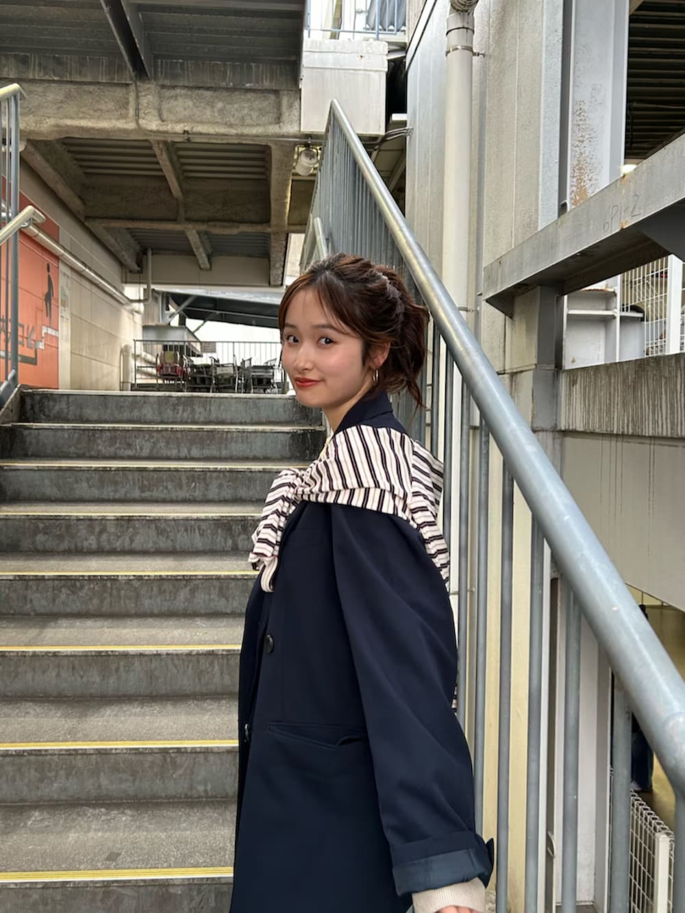 イエロー系のニット/セーター、ブルー系のテーラードジャケット、ブルー系のデニムパンツを着用したレディースの冬コーディネートの8枚目の写真