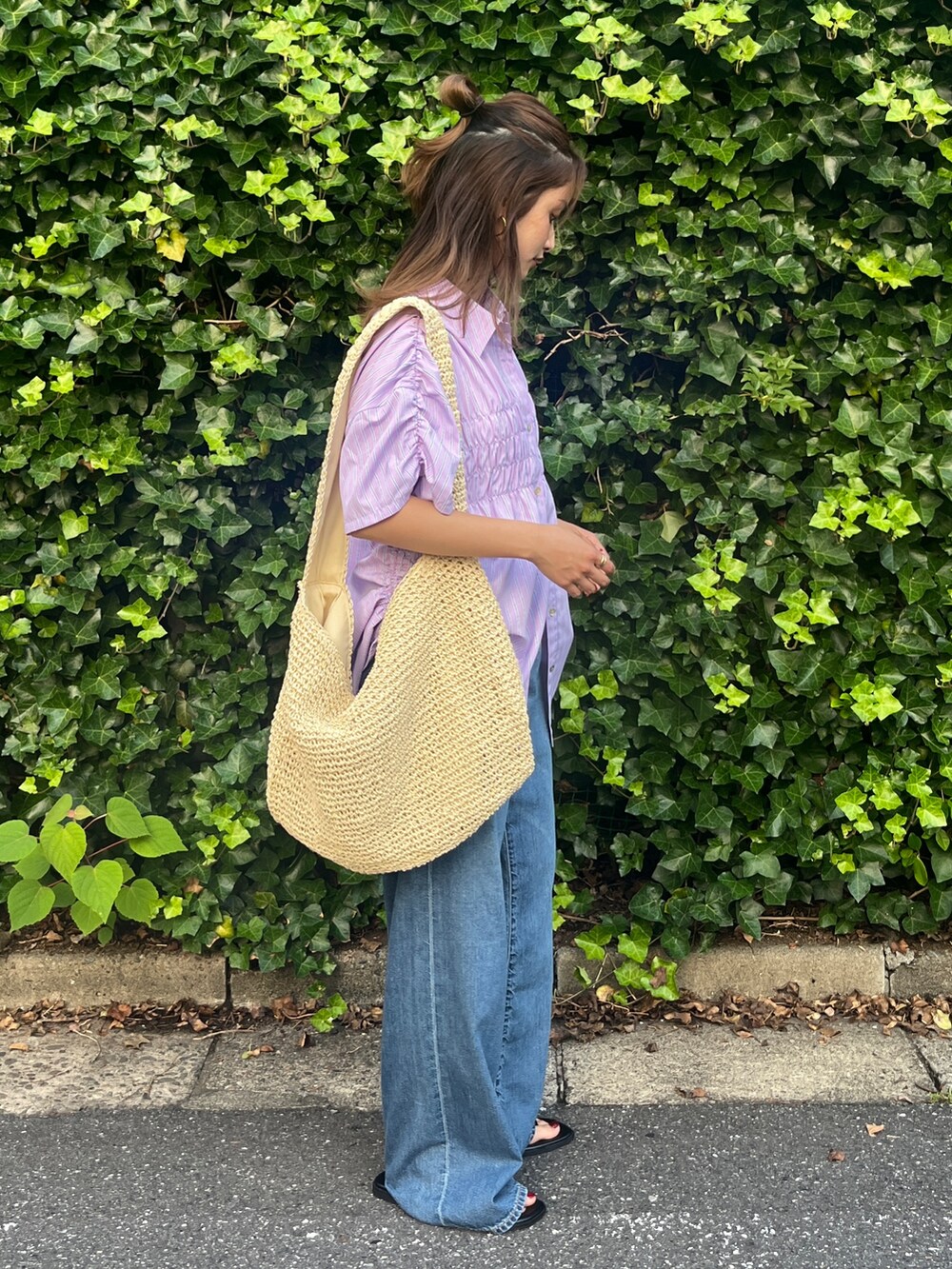 ブルー系のデニムパンツ、ブラック系のサンダル、パープル系のシャツ/ブラウスを着用したレディースの夏コーディネートの2枚目の写真