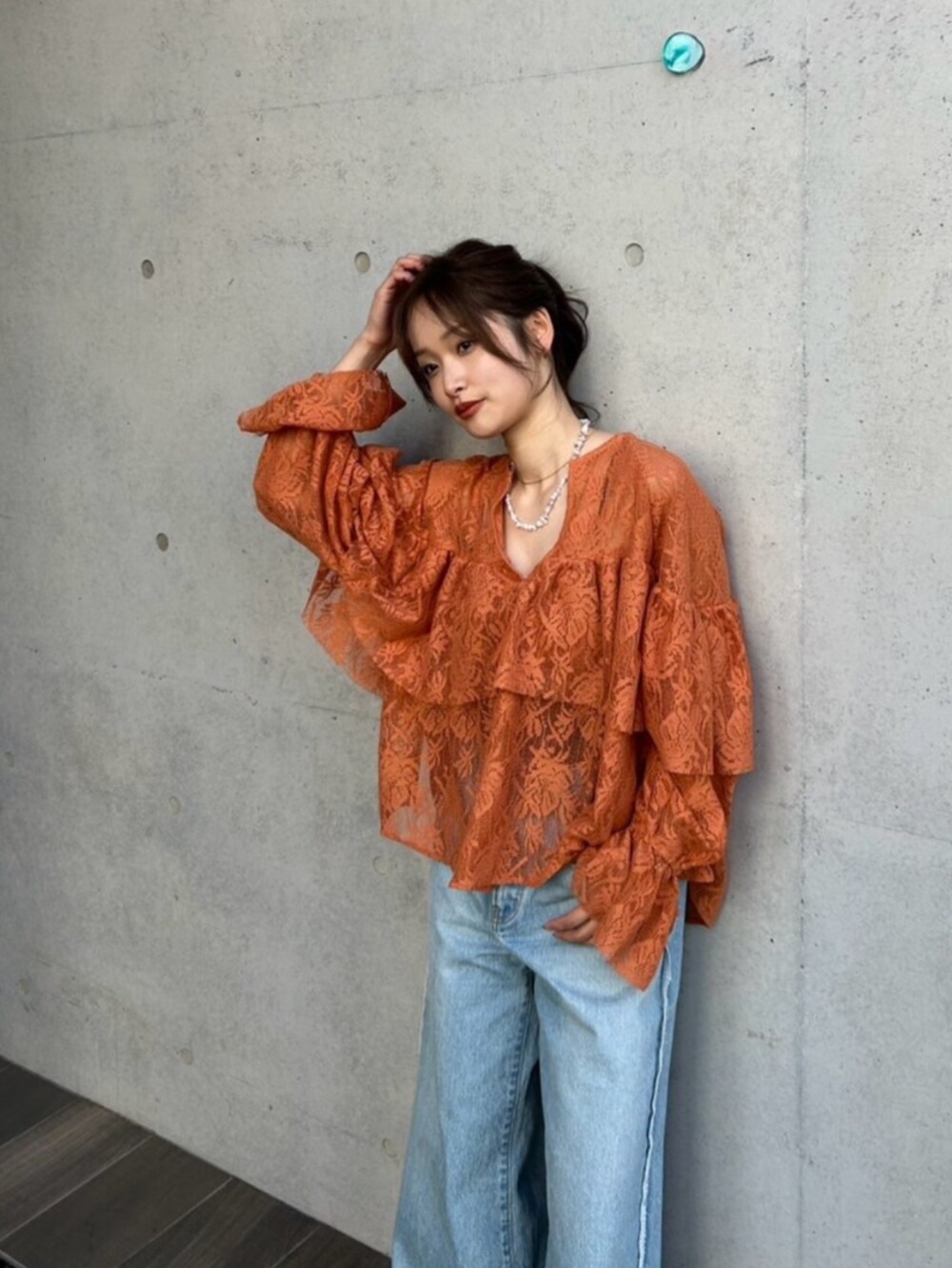 ブルー系のデニムパンツ、ブラック系のパンプス、オレンジ系のシャツ/ブラウスを着用したレディースの冬コーディネートの5枚目の写真